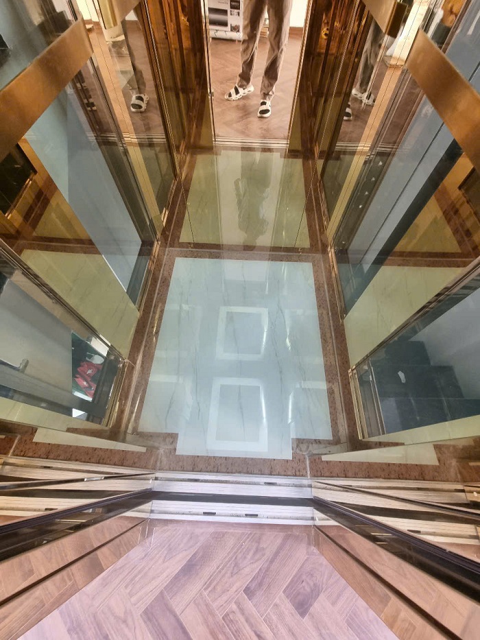 Sàn cabin thang máy kính cường lực trắng viền vàng