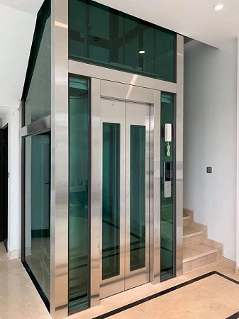 Thang máy kính inox sọc nhuyễn trắng kết cấu khung thép sơn tĩnh điện đen ốp inox