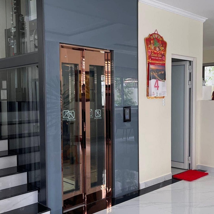 Thang máy hệ khung hép vách kính, cửa tầng SO 800mm inox gương hồng lùa về bên phải