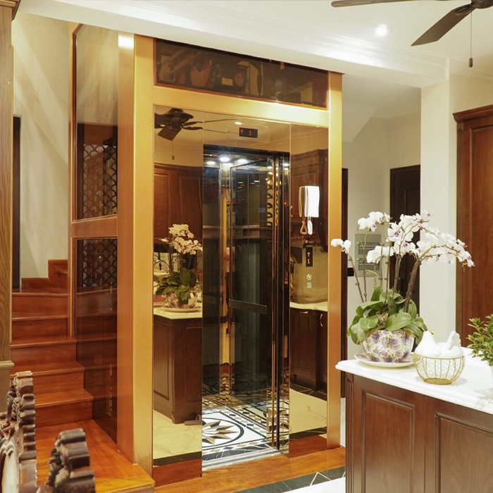 Thang máy khung thép vách kính đen, cửa tầng khung bao bản rộng