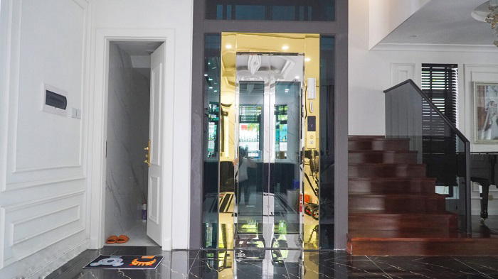 Thang máy kính kết hợp inox gương vàng và inox sọc trắng