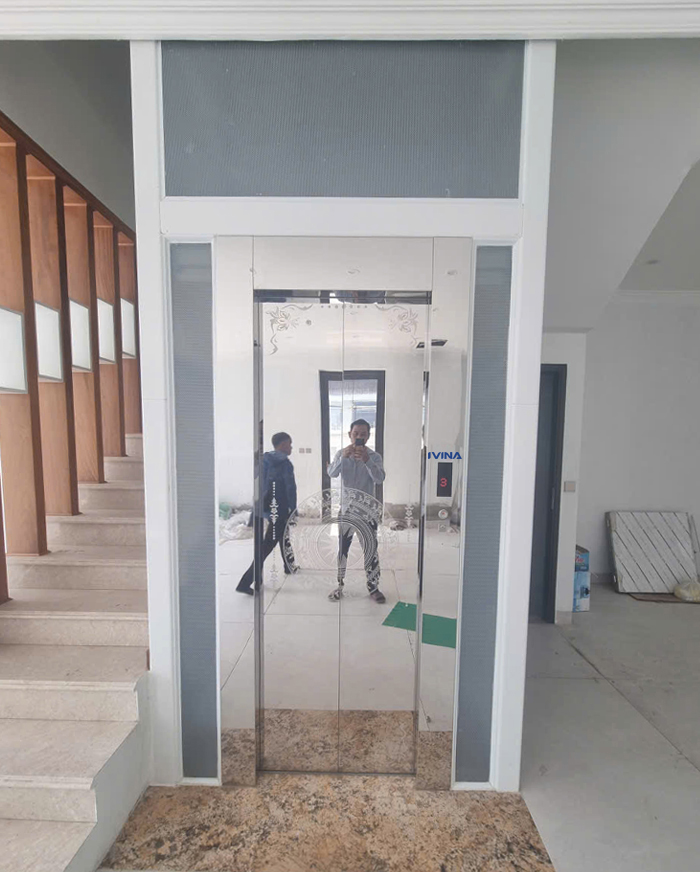 Cửa tầng Inox trắng gương hoa văn ăn mòn hình trống đồng kích thước CO 700 x 2100 mm mở tim về hai phía