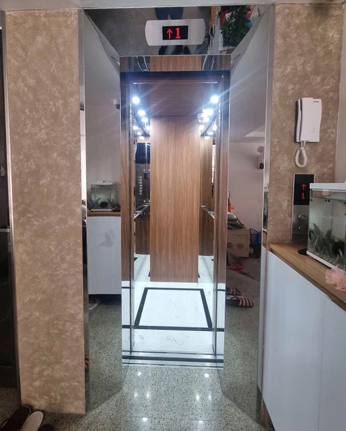 Cabin thang máy kích thước 1050 x 1050 mm inox trắng gương xen inox dán vân gỗ ở giữa
